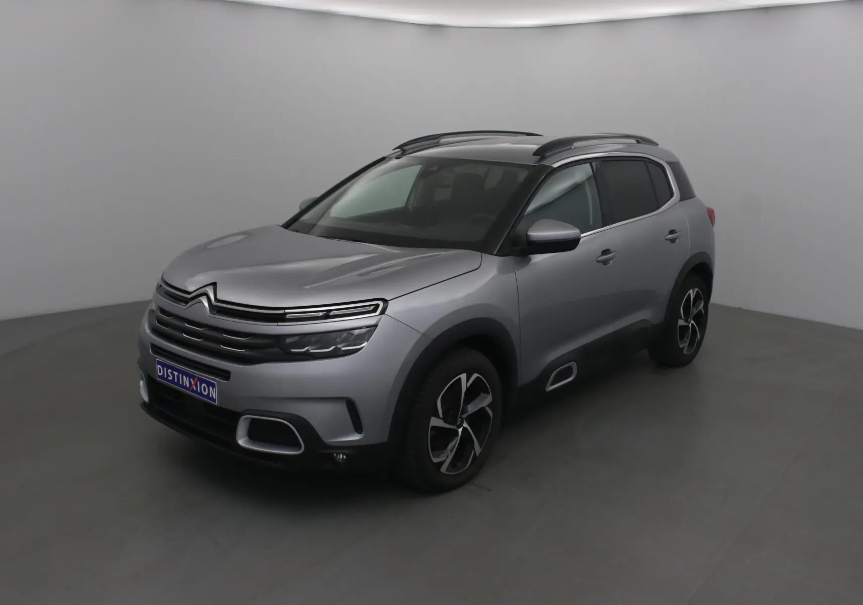 Citroën C5 Aircross gris Artense en 3/4 avant droit, avec jantes noires et toit noir contrasté.