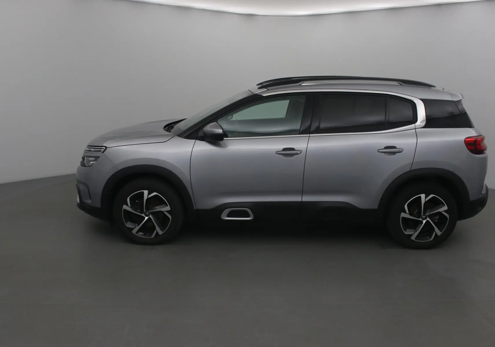 Citroën C5 Aircross gris Artense vu de profil côté gauche, avec jantes alliage et barres de toit noires.
