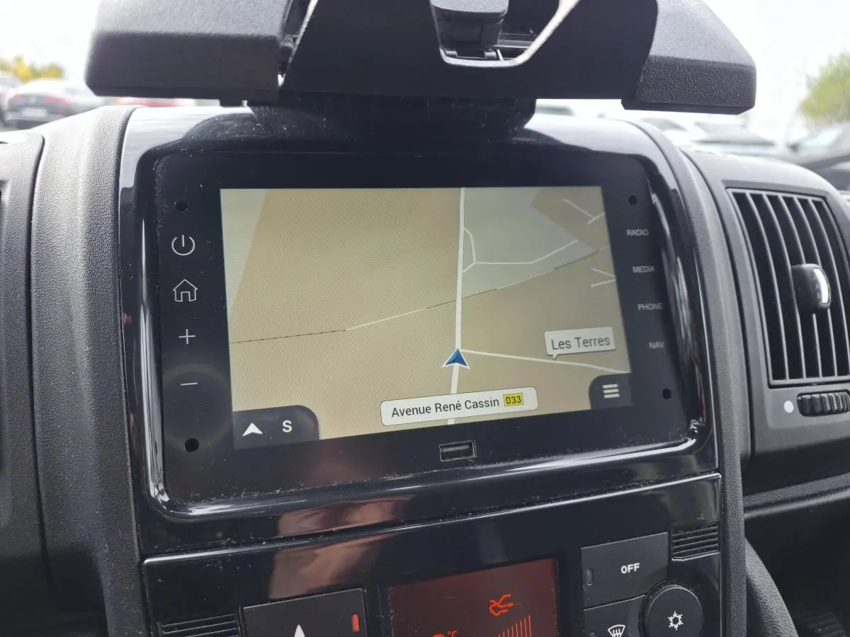 Écran tactile central avec navigation affichant une carte, dans l'habitacle d'un Opel Movano blanc.