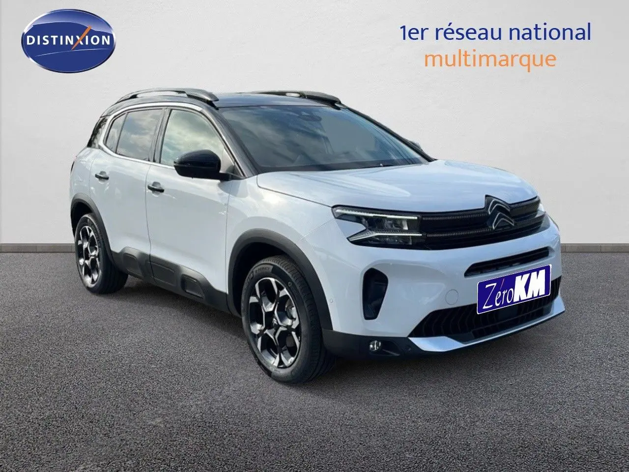 SUV Citroën C5 Aircross blanc 3/4 avant droit avec toit noir et jantes bi-ton sur fond neutre.