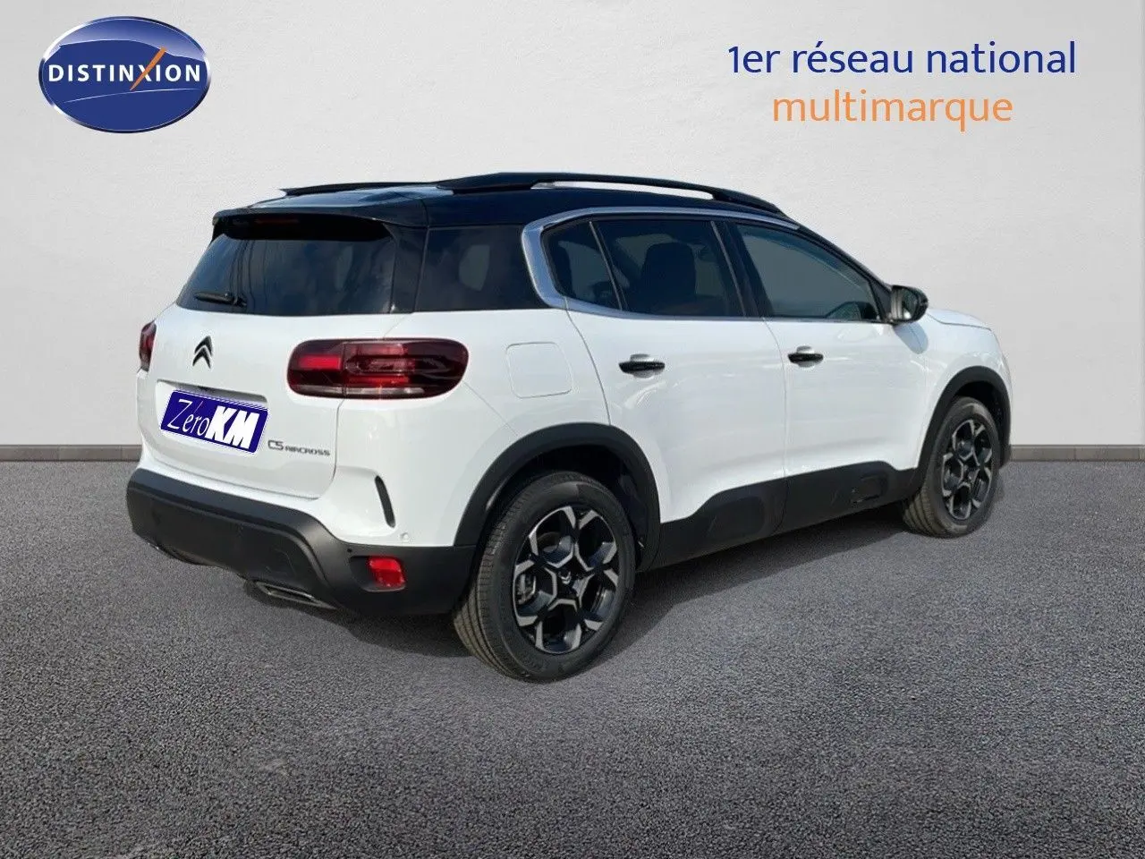 Vue 3/4 arrière droite du Citroën C5 Aircross blanc Okenite avec toit noir et jantes biton distinctives.