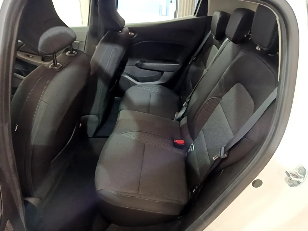 Vue intérieure arrière droite de la Renault Clio Business blanche, montrant la banquette 3 places en tissu noir.