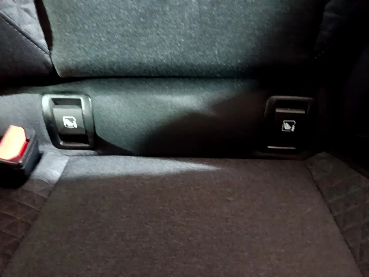 Gros plan sur la banquette arrière noire de la Renault Clio Business, montrant les commandes de rabattement 2/3-1/3.