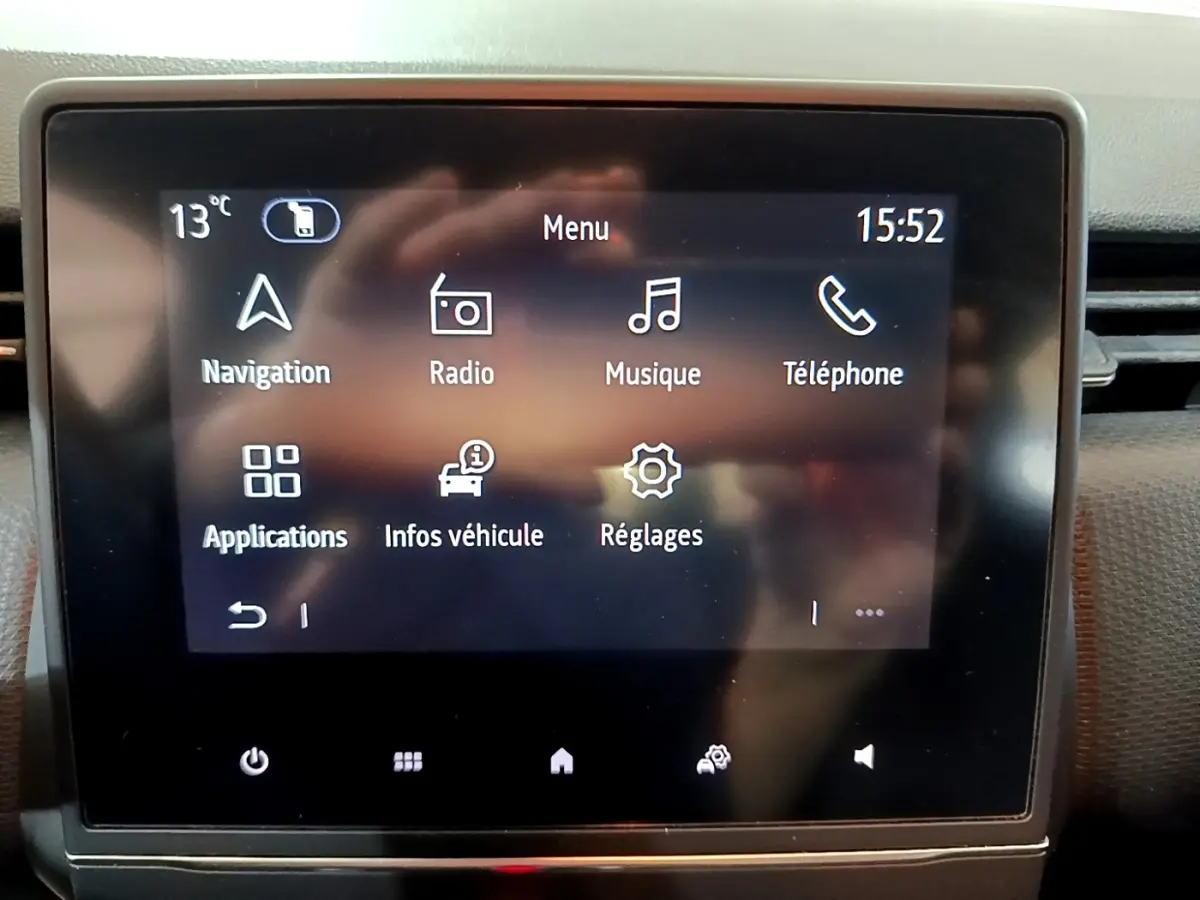 Écran tactile central de la Renault Clio Business blanc, affichant le menu principal avec navigation et radio.