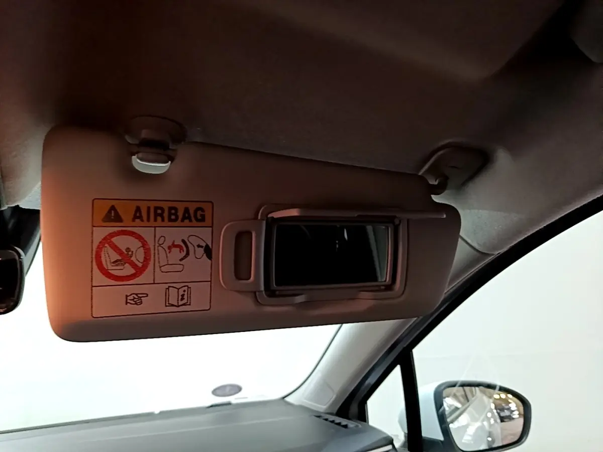 Détail du pare-soleil côté conducteur de la Renault Clio Business blanche 2021 avec miroir et avertissement airbag visible.