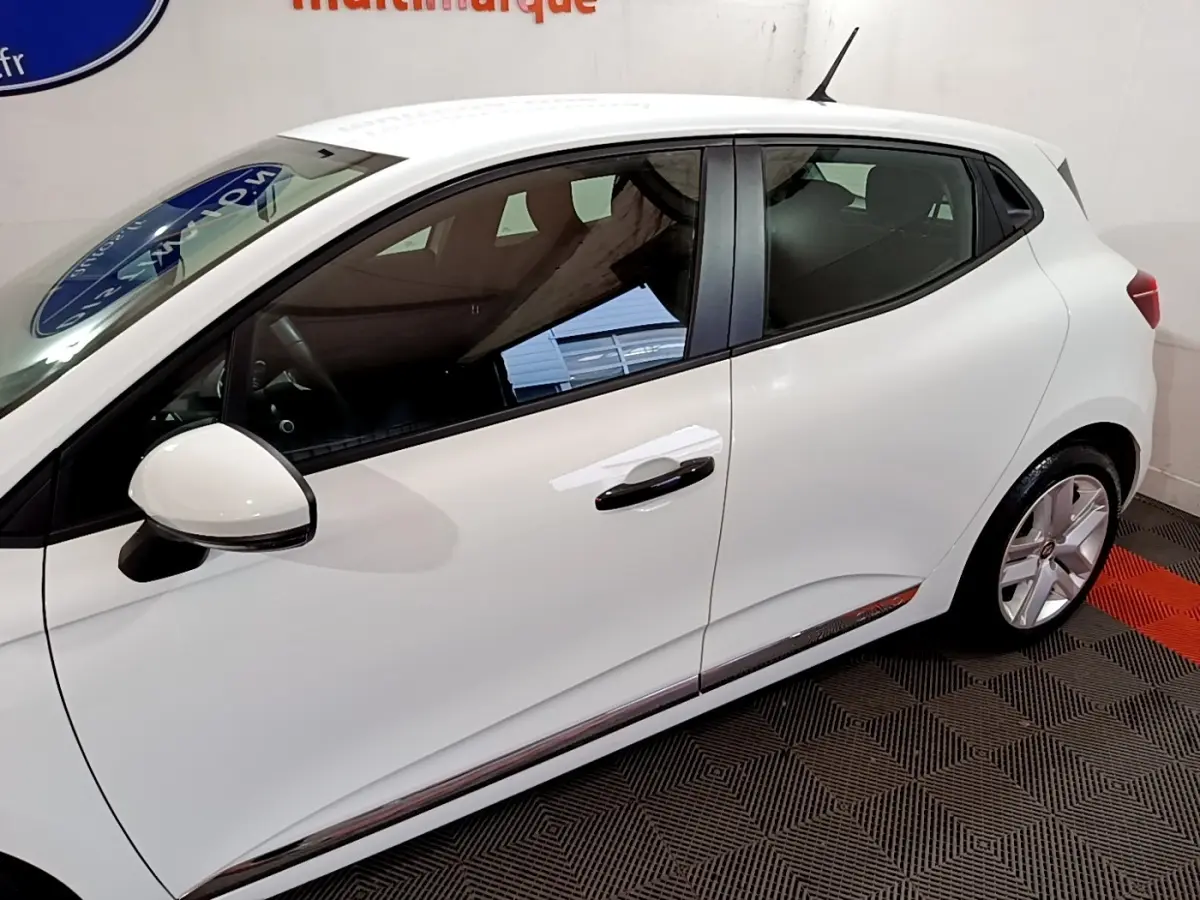 Profil droit d'une Renault Clio Business blanche, mettant en valeur la ligne fluide et les jantes alliage.
