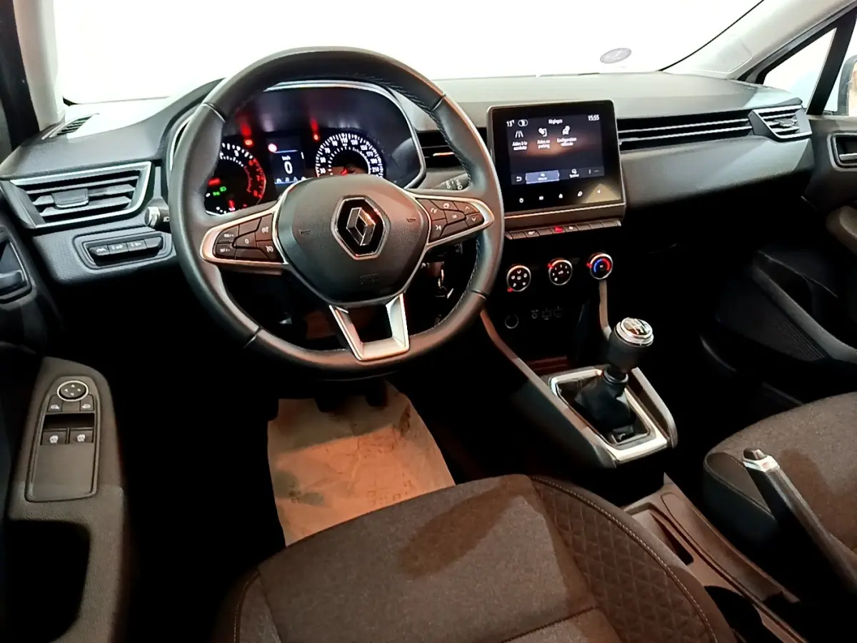 Vue intérieure avant de la Renault Clio Business blanche, volant cuir multifonctions et écran tactile central 7 pouces.