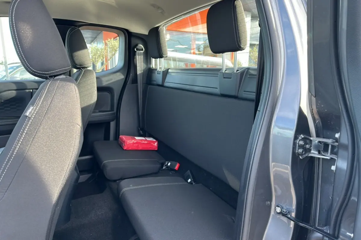 Vue intérieure côté droit du Ford Ranger Supercab 2026 noir shadow, montrant la banquette arrière et un accoudoir central relevé.