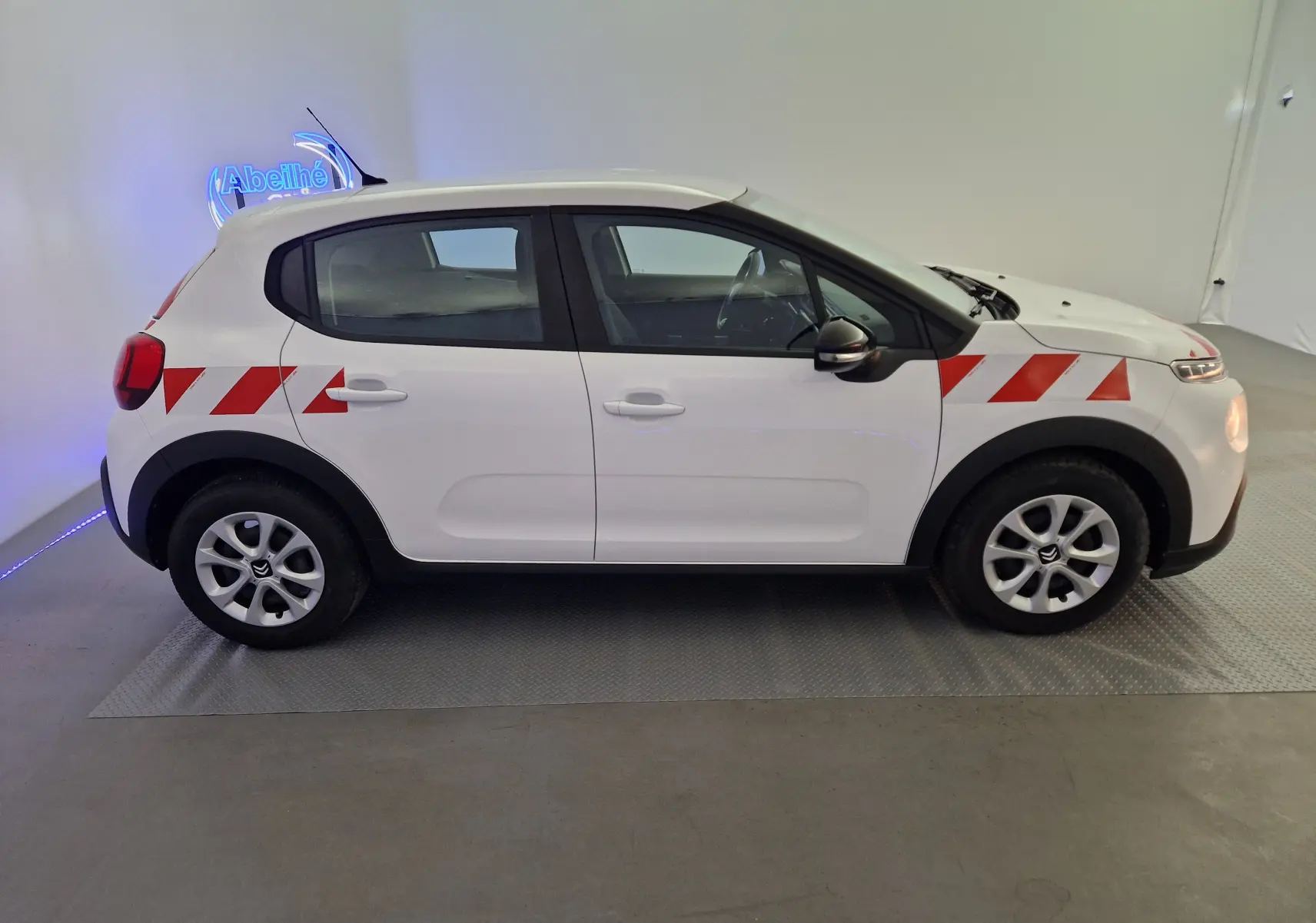 Profil droit d'une Citroën C3 Société blanche 2019 avec bandes rouges diagonales sur ailes avant et arrière.