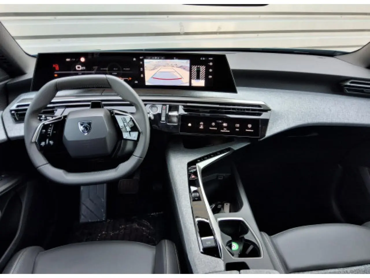 Vue intérieure avant du Peugeot 3008 2026, tableau de bord moderne avec écran incurvé et volant compact noir.
