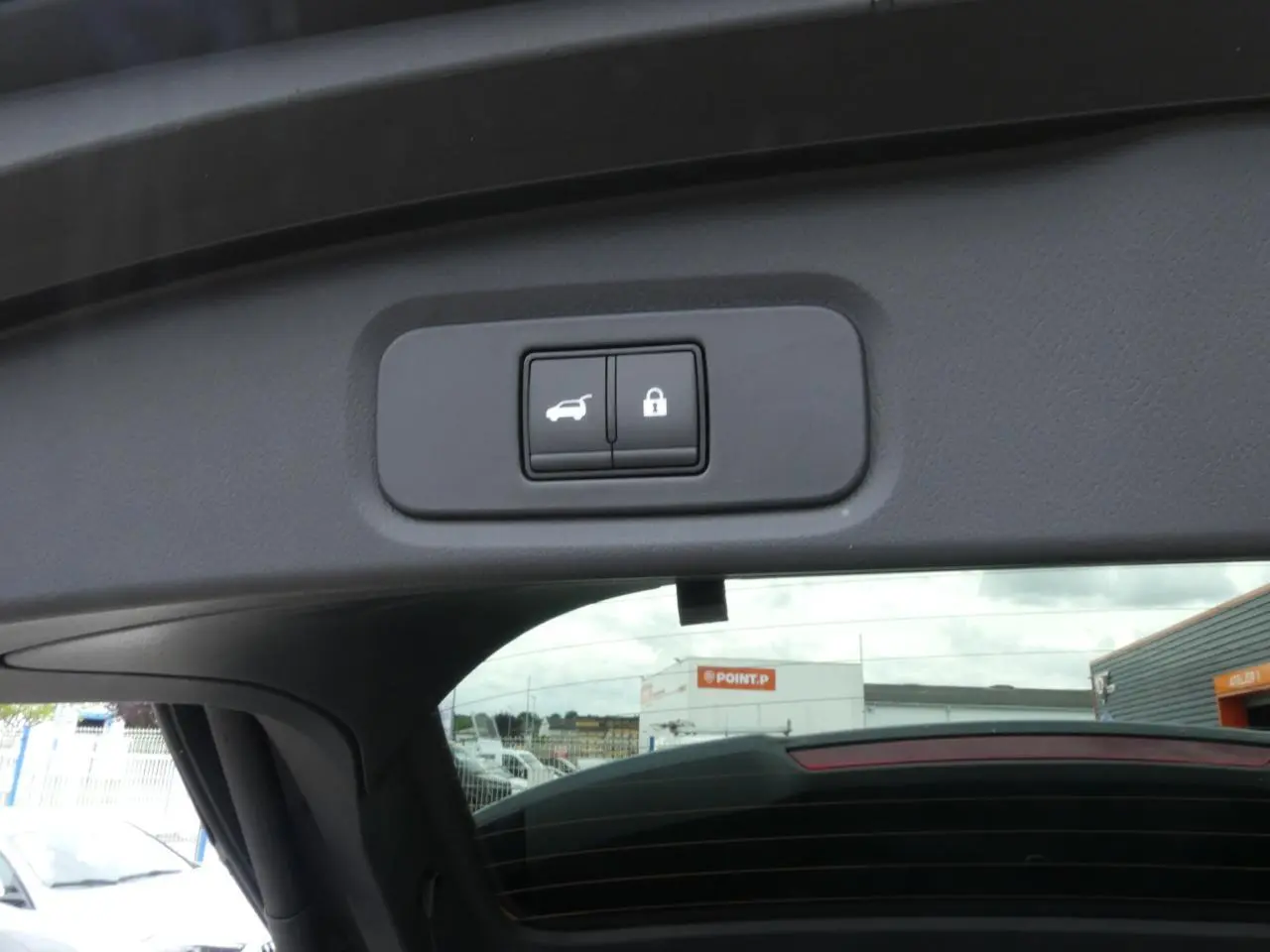 Détail du bouton de hayon électrique et verrouillage sur le bord intérieur du coffre du Nissan Qashqai gris métallisé 2025.