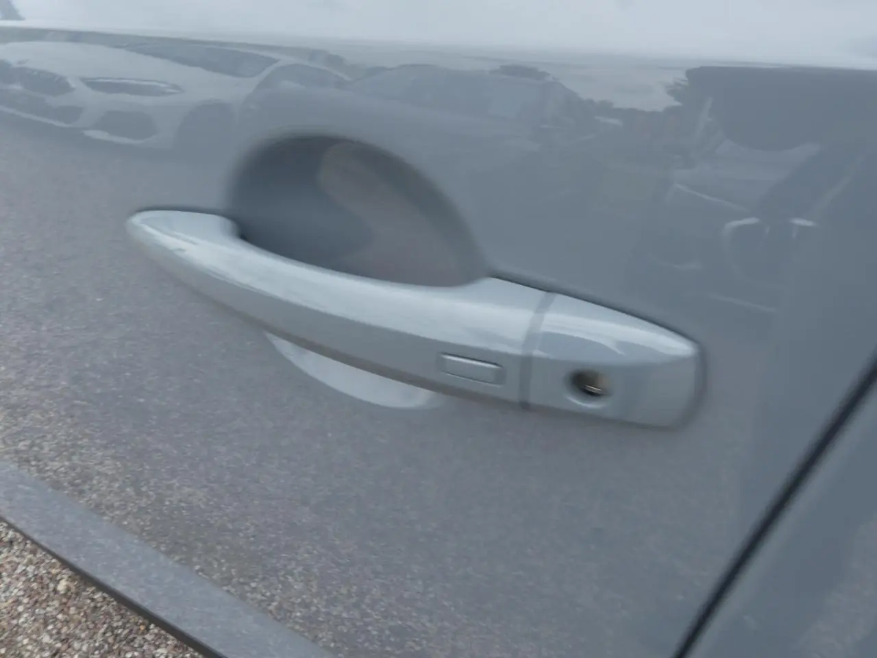 Poignée de porte côté droit gris métallisé du Nissan Qashqai 1.5 e-Power 2025 avec serrure visible.