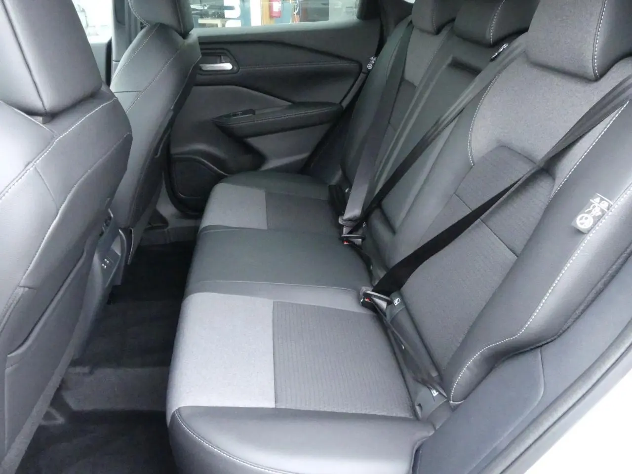 Vue latérale droite de la banquette arrière bicolore en tissu et TEP du Nissan Qashqai 1.5 e-Power 2025.
