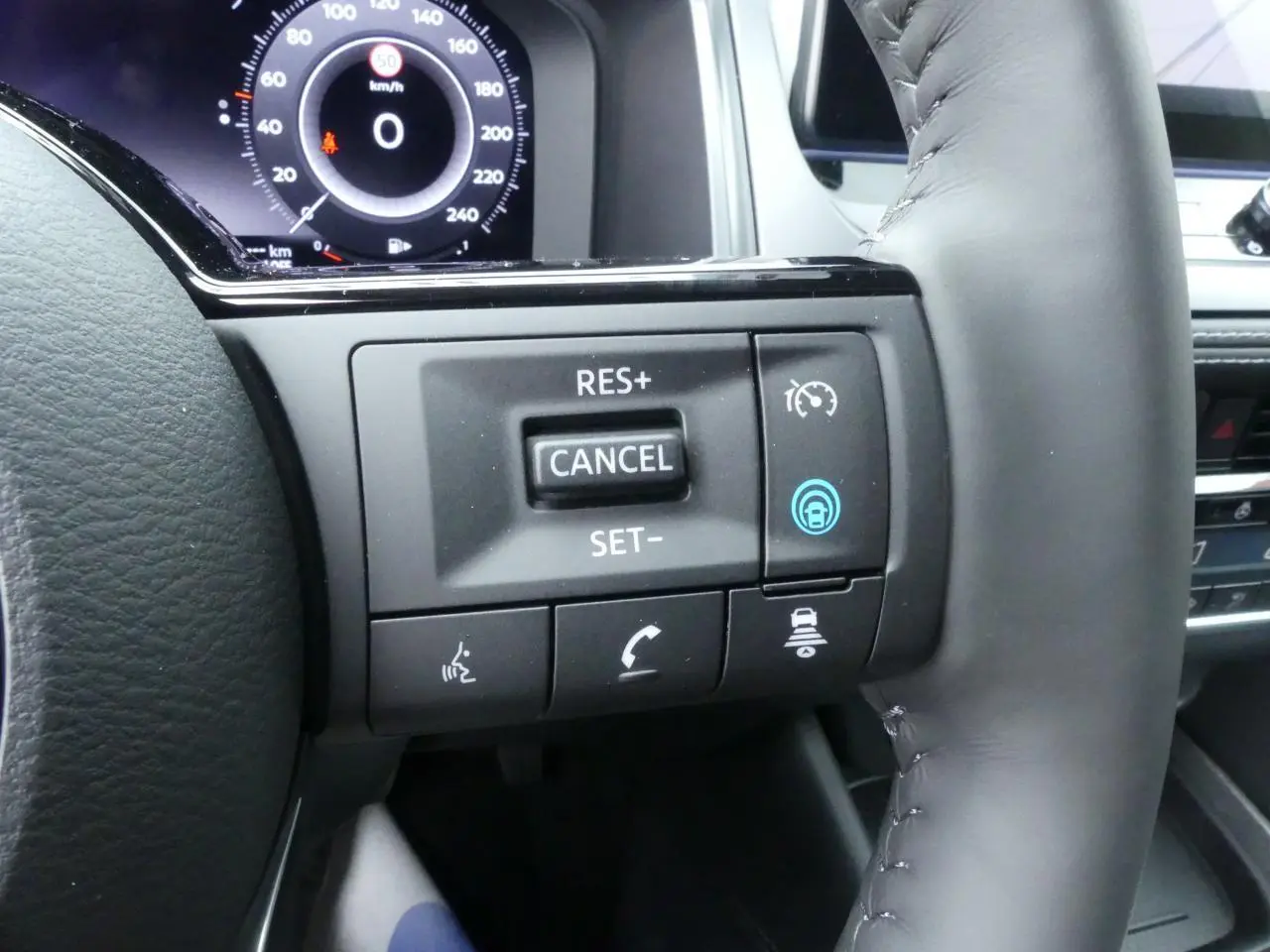 Gros plan sur les commandes du volant cuir noir du Nissan Qashqai 1.5 e-Power 2025 avec affichage numérique au tableau de bord.
