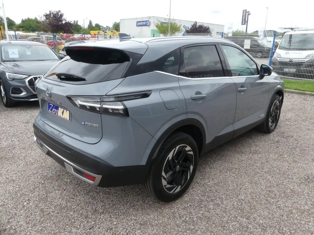 Vue 3/4 arrière droite du Nissan Qashqai 1.5 e-Power gris métallisé avec toit noir et jantes alliage 18 pouces.