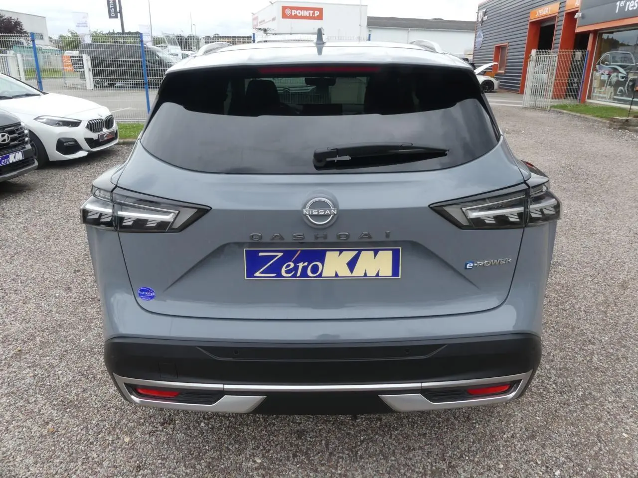Vue arrière d'un Nissan Qashqai gris métallisé e-Power avec feux LED et logo distinctif sur hayon fermé.