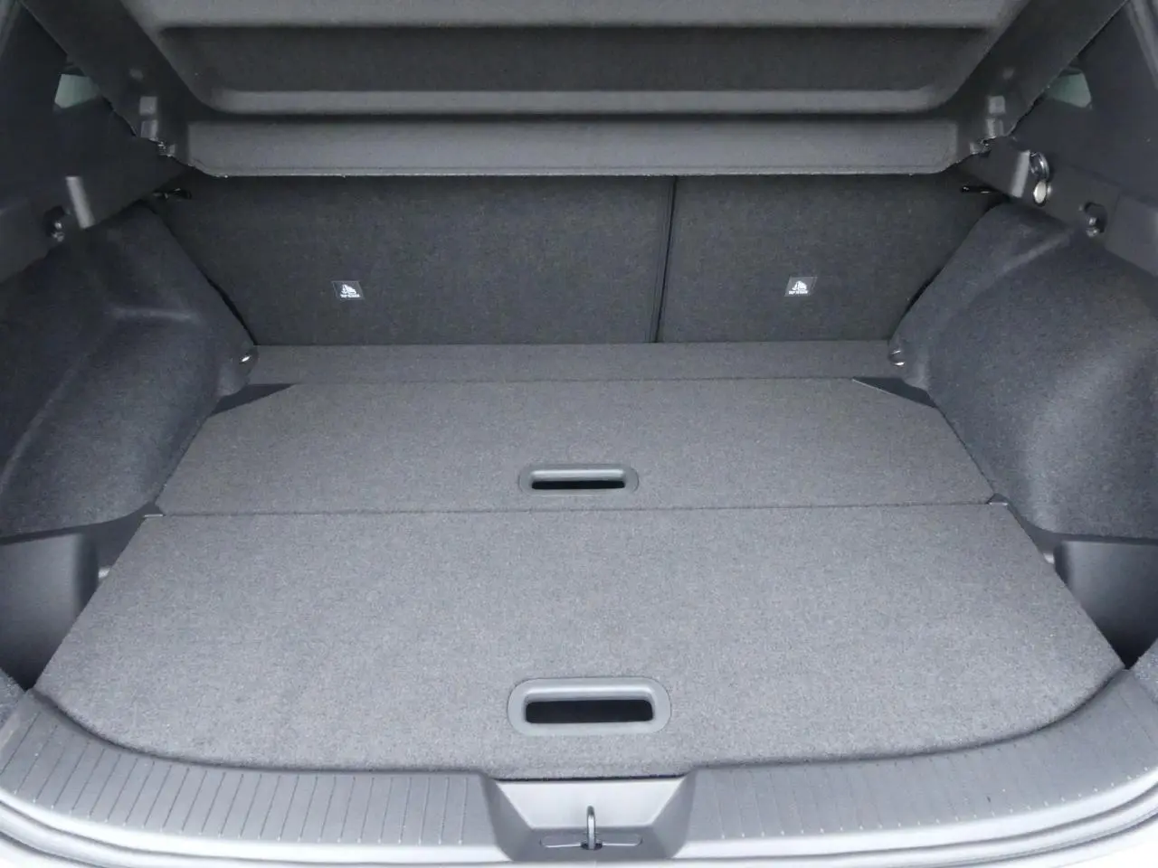 Coffre spacieux du Nissan Qashqai 1.5 e-Power gris métallisé avec plancher modulable et crochets de fixation visibles