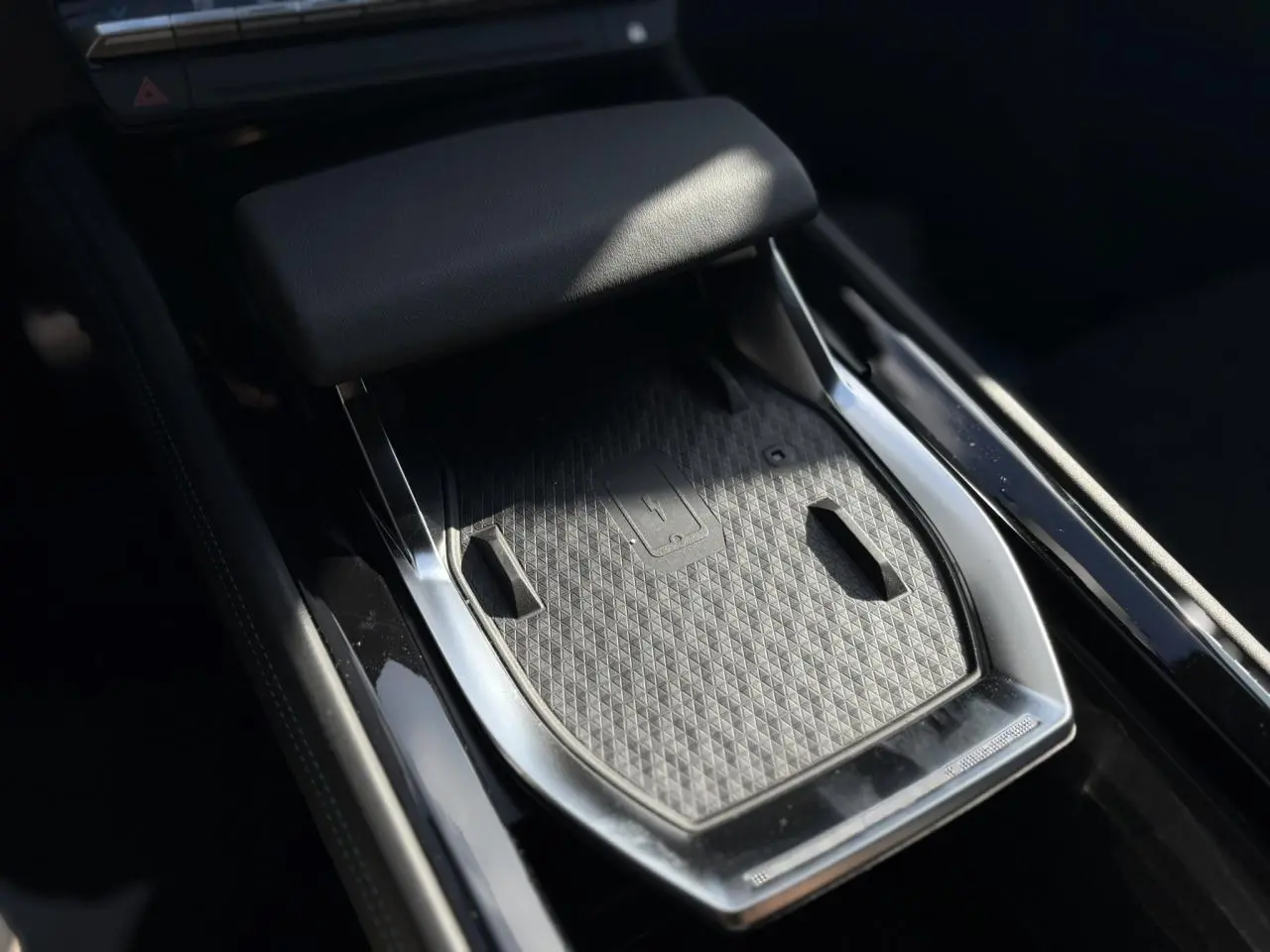 Plateau de recharge sans fil gris et noir au centre de la console de la Renault Rafale E-Tech Full Hybrid 2025.