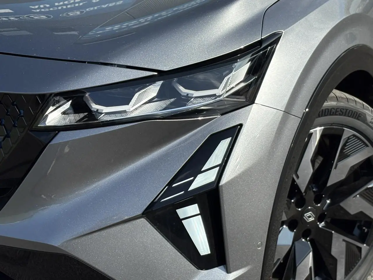 Détail du phare avant droit et jante noire diamantée du Renault Rafale gris schiste 2025 E-Tech Full Hybrid.