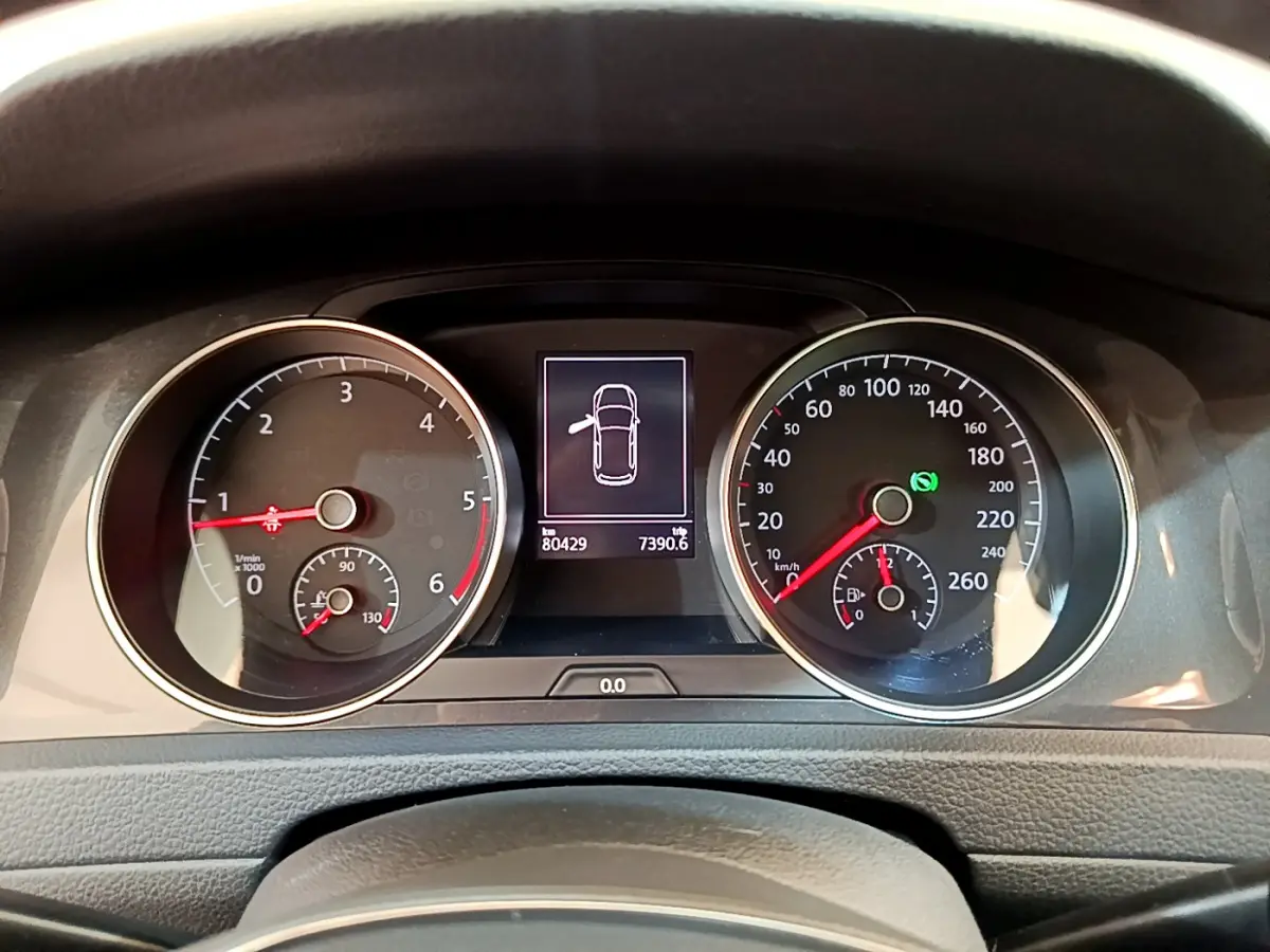 Tableau de bord de Volkswagen Golf gris clair 2019, affichage digital au centre avec compteurs ronds analogiques.