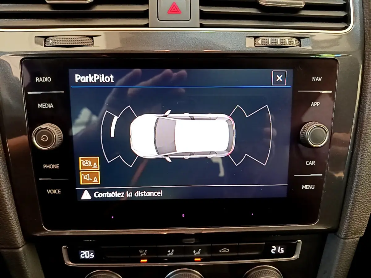 Écran tactile central affichant le système ParkPilot de la Volkswagen Golf 1.6 TDI 2019 en vue de dessus du véhicule blanc.