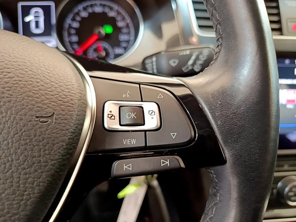 Gros plan sur les commandes multifonctions du volant cuir noir d'une Volkswagen Golf 1.6 TDI 2019.