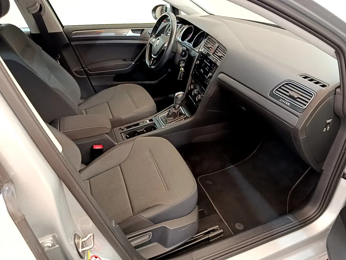 Intérieur avant droit de la Volkswagen Golf 1.6 TDI 2019, sièges gris foncé et tableau de bord avec écran tactile.