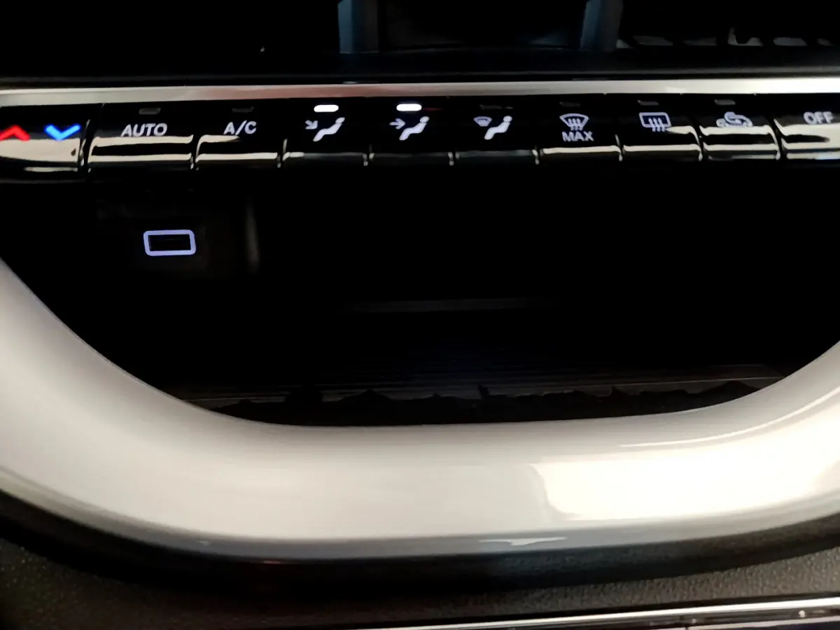 Gros plan sur les commandes de climatisation et la console blanche brillante de la FIAT 500 électrique 42kWh Icône.