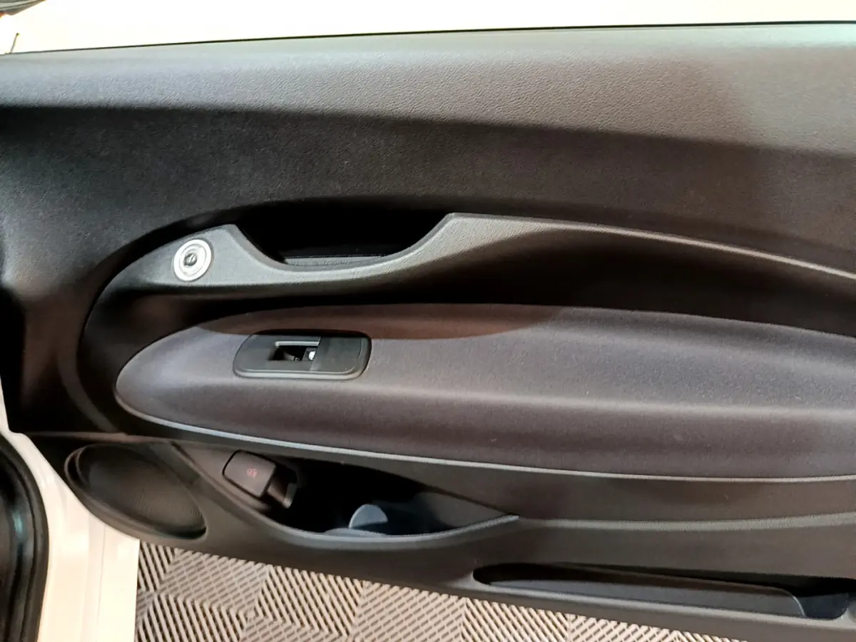 Détail de la porte côté gauche noire du FIAT 500 42kWh Icône blanc, avec poignée et commande de vitre.