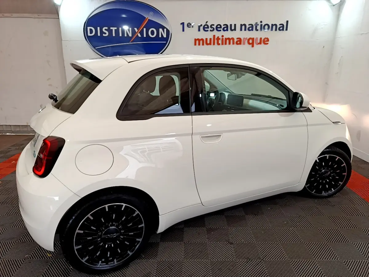 Profil droit d'une Fiat 500 électrique blanche 42kWh Icône 2022, avec jantes noires et vitres teintées.