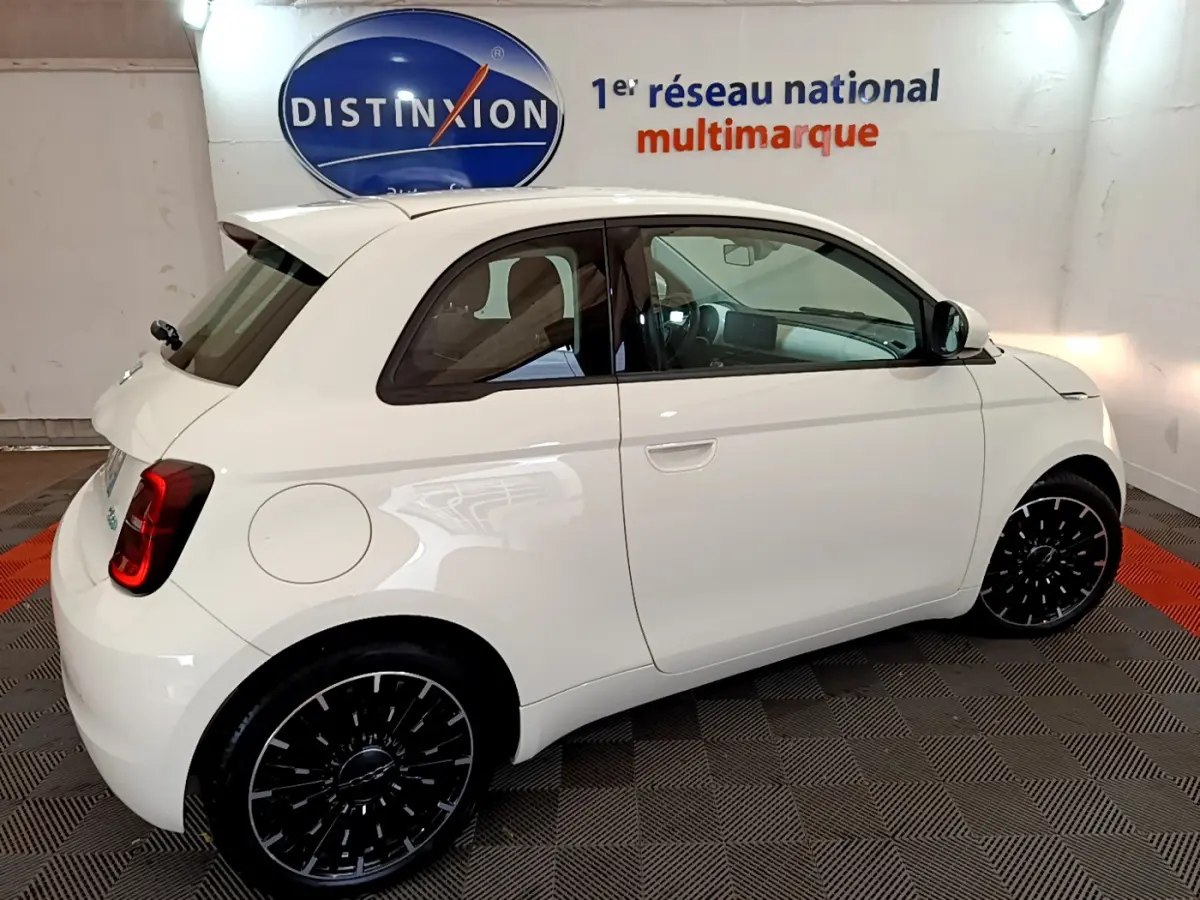 Vue côté droit d'une FIAT 500 électrique blanche version 42kWh Icône avec jantes noires stylisées.