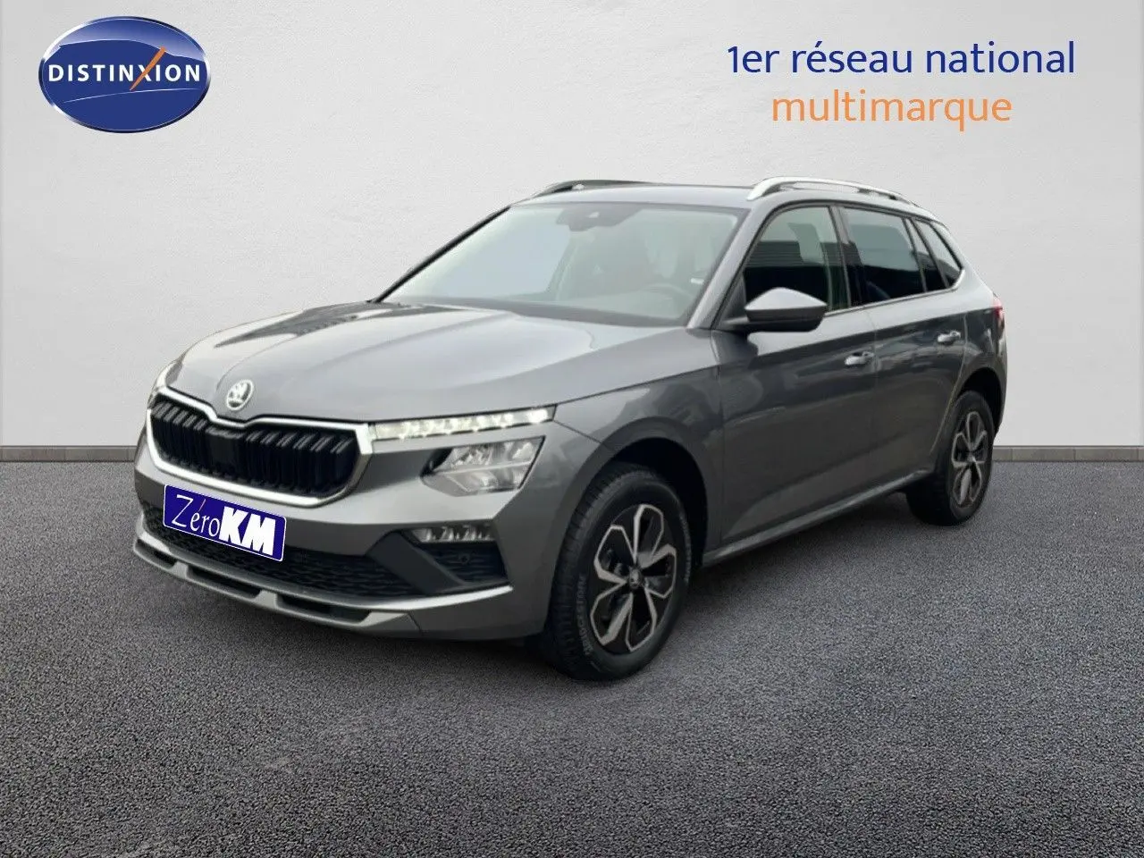 Vue 3/4 avant droite d'un Skoda Kamiq gris graphite métal 2025 avec jantes bi-ton et toit ouvrant.