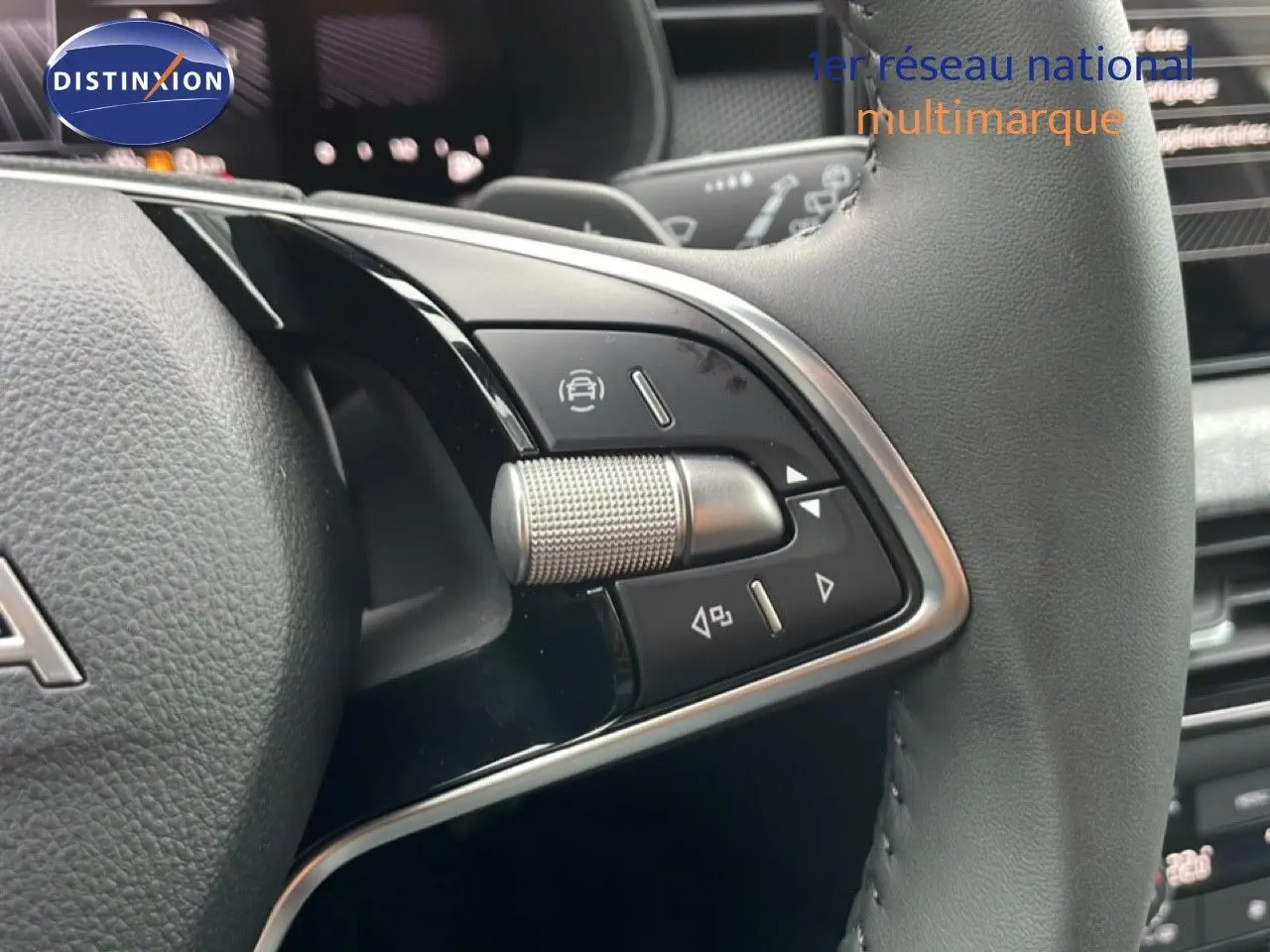 Gros plan sur les commandes du volant en cuir noir du Skoda Kamiq gris graphite, mettant en valeur la molette métallique et les boutons multifonctions.