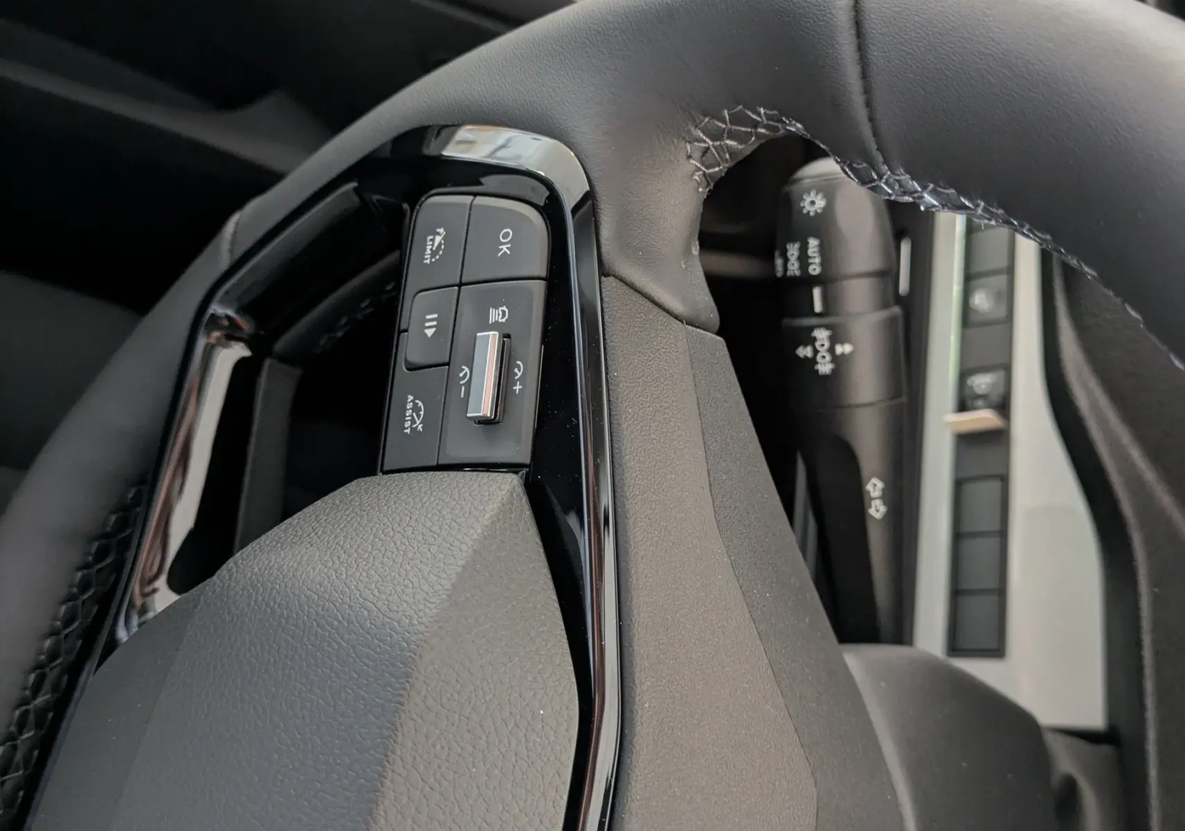 Gros plan sur le volant noir du Peugeot Traveller 2026, avec commandes intégrées et logo Peugeot visible.