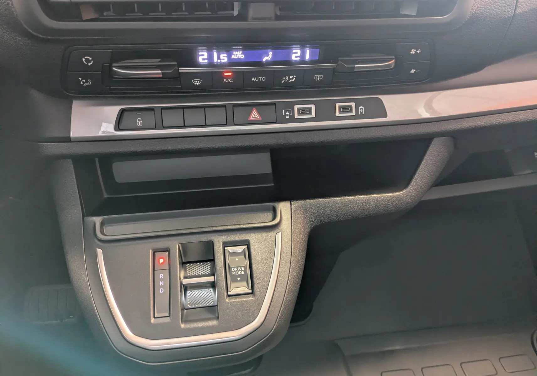 Vue rapprochée de la console centrale du Peugeot Traveller noir 2026, avec commandes climatisation et boîte auto.