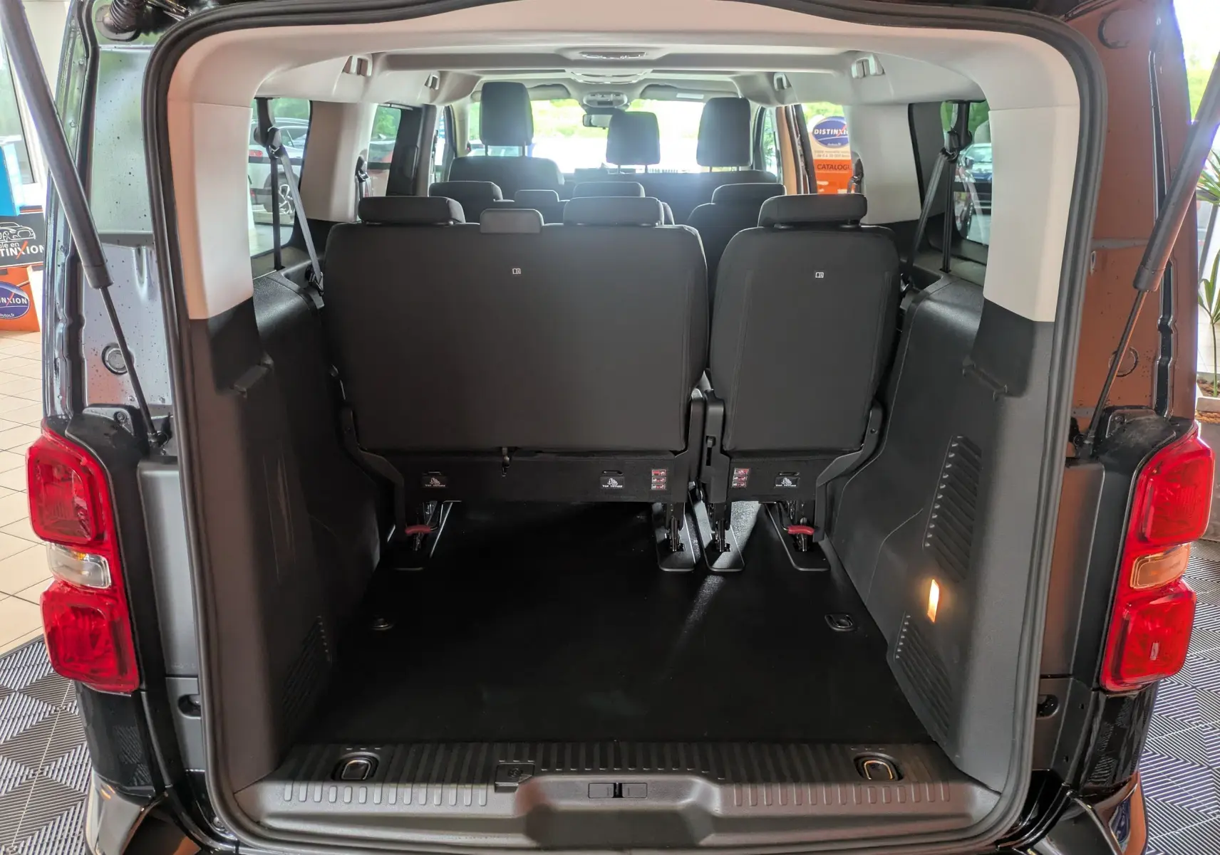 Vue arrière ouverte du Peugeot Traveller noir 2026 montrant l'espace de chargement et les sièges arrière rabattus.