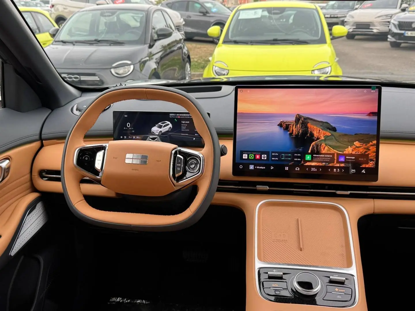 Vue intérieure du tableau de bord et volant cuir beige du Geely STARRAY 1.5 EM-i 262ch avec grand écran tactile central.