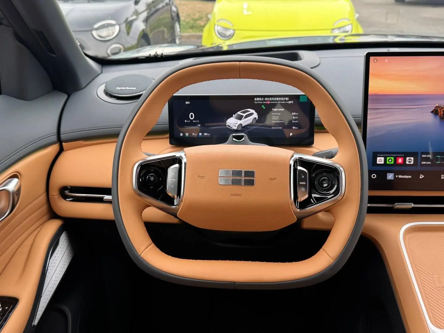 Vue intérieure centrée sur le volant cuir beige et les écrans numériques du tableau de bord du Geely STARRAY 2026.