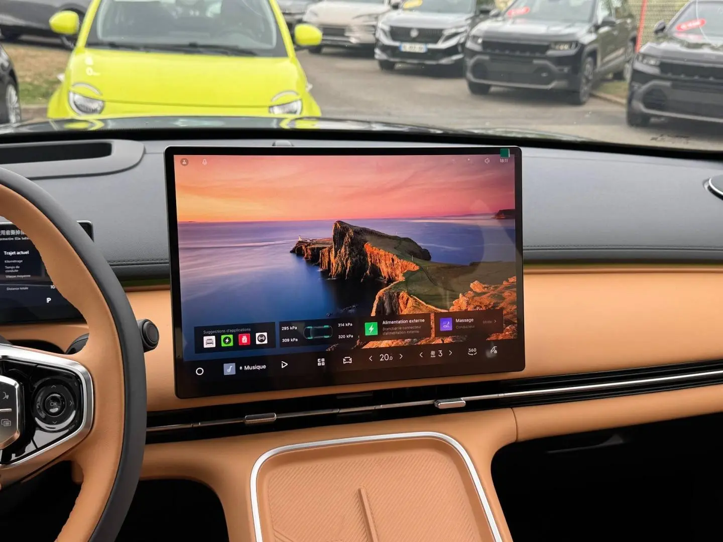Vue intérieure du tableau de bord beige du Geely STARRAY 1.5 EM-i avec grand écran tactile central allumé.