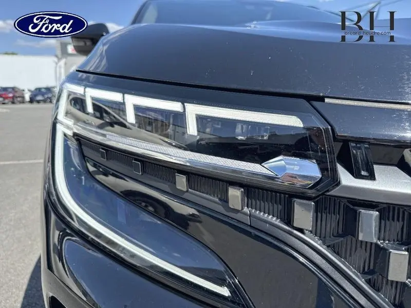 Gros plan sur le phare avant droit noir étoilé du Renault Austral 2024 avec hayon motorisé et détails LED distinctifs.