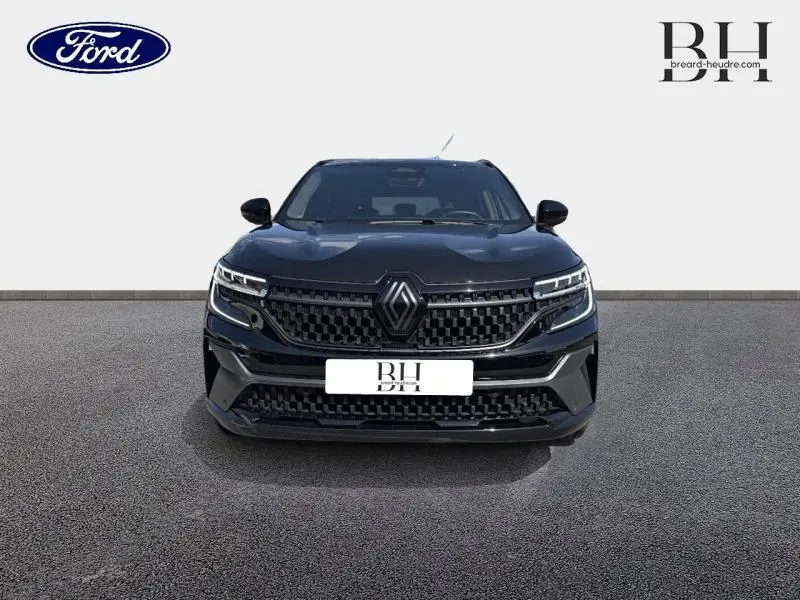 Vue frontale d'un Renault Austral noir étoilé avec calandre et phares LED distinctifs sur fond neutre.