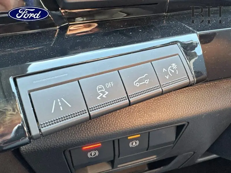 Gros plan sur les boutons de commande d'aide à la conduite et d'éclairage dans l'habitacle d'un Renault Austral noir étoilé 2024