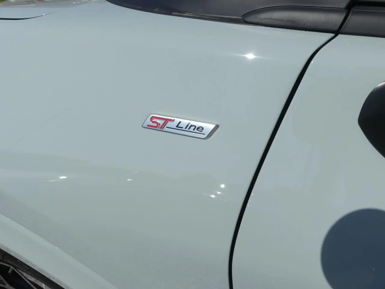 Gros plan sur l'emblème ST-Line sur la porte avant gauche d'un Ford Puma gris métallisé 2025.