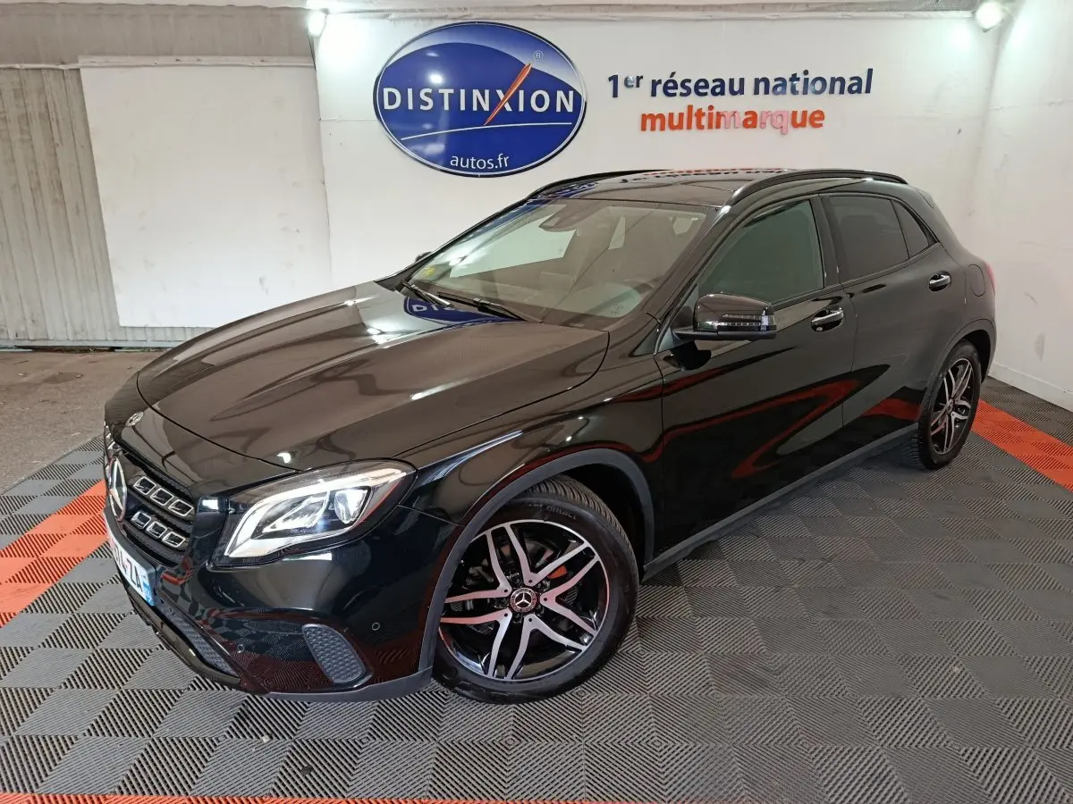 Mercedes GLA 220 d noir vue 3/4 avant droit, avec jantes alliage et phares LED dans un showroom intérieur.