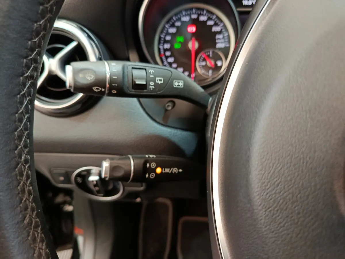 Gros plan sur le volant cuir et commandes au volant du tableau de bord noir du Mercedes GLA 220 d 2018.