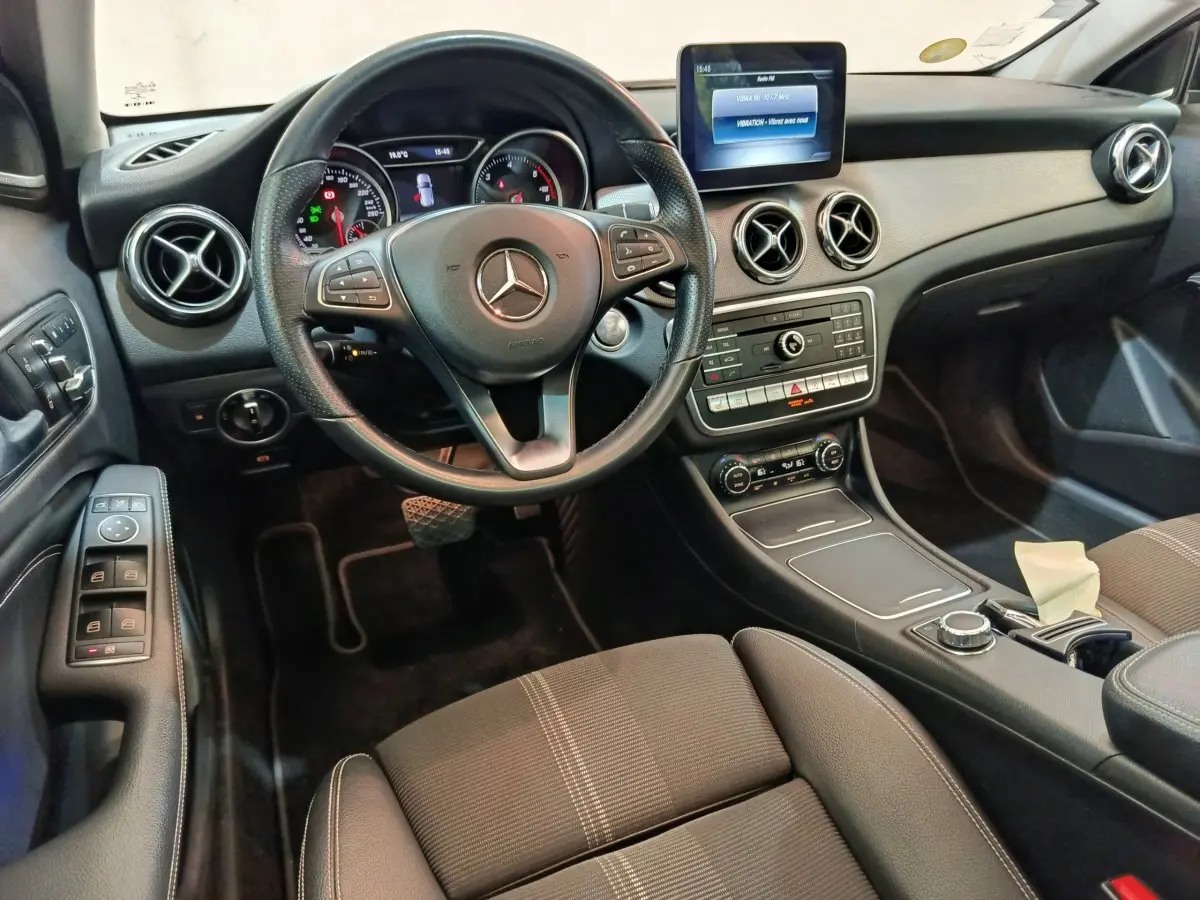 Intérieur noir du Mercedes GLA 220 d 2018 vu côté conducteur, volant cuir et écran multimédia central visible.