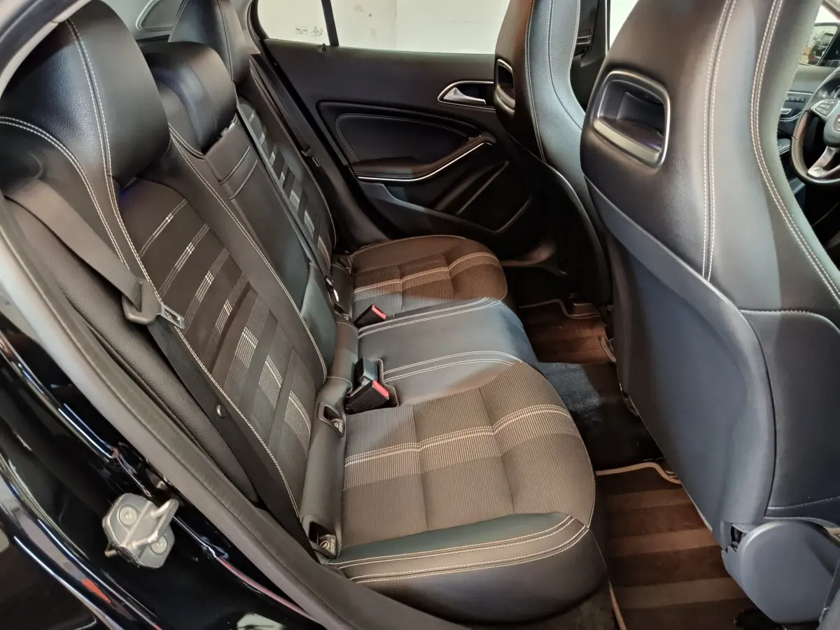 Vue intérieure côté gauche sur la banquette arrière noire avec surpiqûres blanches du Mercedes GLA 220 d 2018.
