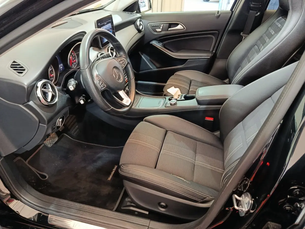 Intérieur noir de la Mercedes GLA 220 d 2018 vu côté conducteur, avec volant cuir multifonctions et console centrale moderne.