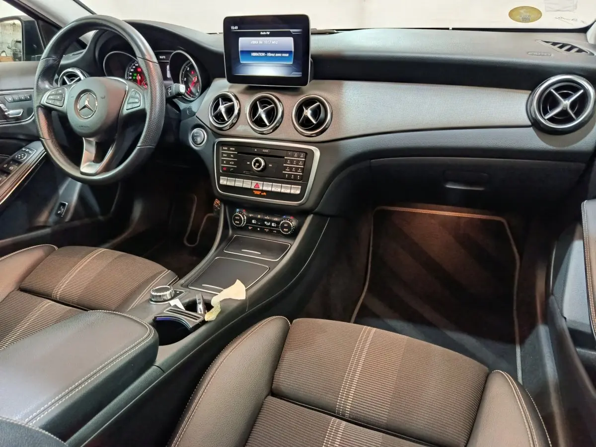 Intérieur noir du Mercedes GLA 220 d 2018 vu côté conducteur, avec tableau de bord et écran central tactile.