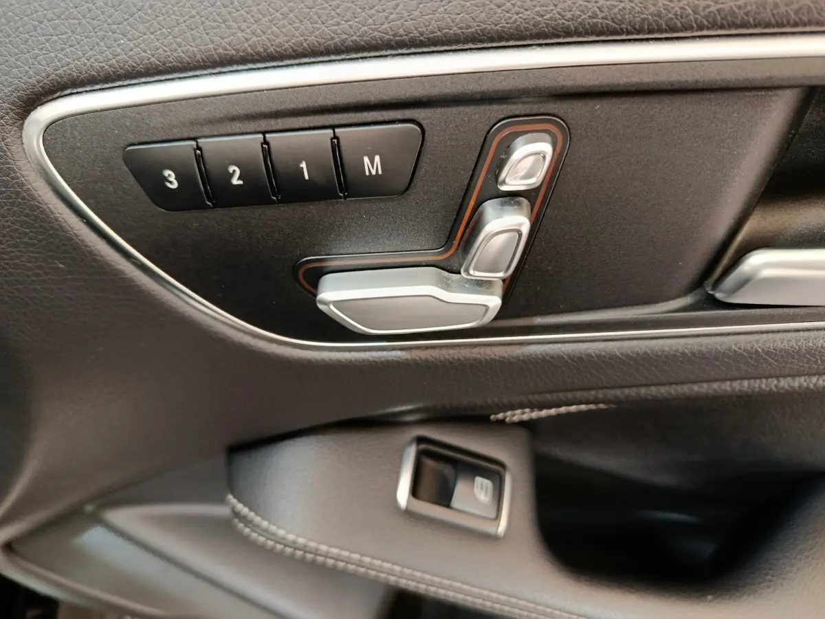 Détail des commandes de réglage de siège en cuir noir côté gauche dans une Mercedes GLA 220 d Business Exec 2018.